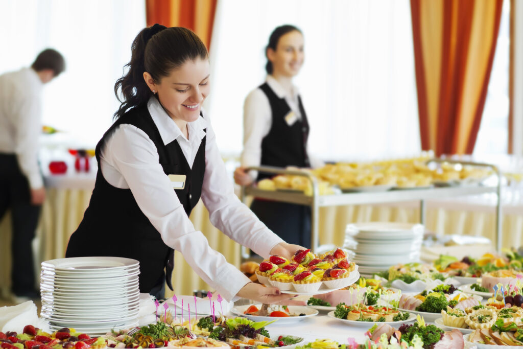 A woman in black shirt holding tray of food.