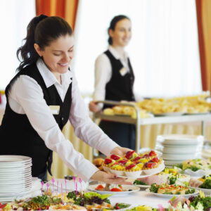 A woman in black shirt holding tray of food.